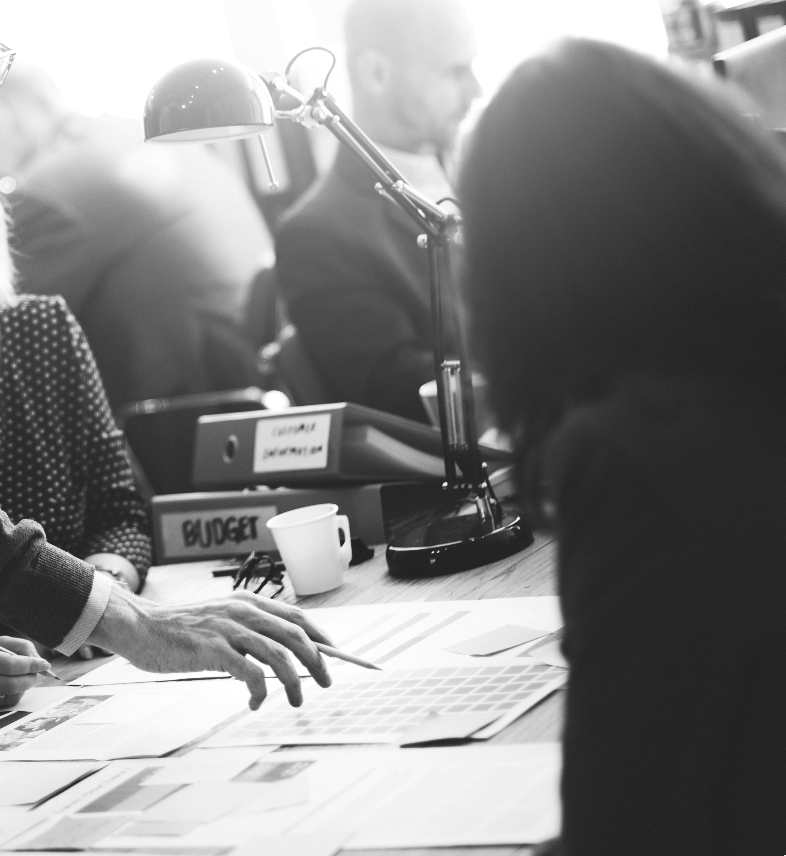 Besprechung am Tisch mit Unterlagen zum Budget in einem modernen Büro.