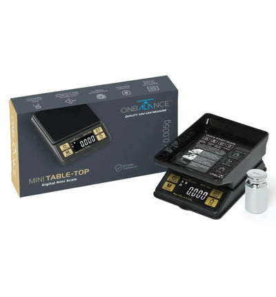 OnBalance MTT 100 Mini Tischwaage mit 100g Kapazität und 0,005g Präzision, zeigt die Waage in Gebrauch auf einer Arbeitsfläche.